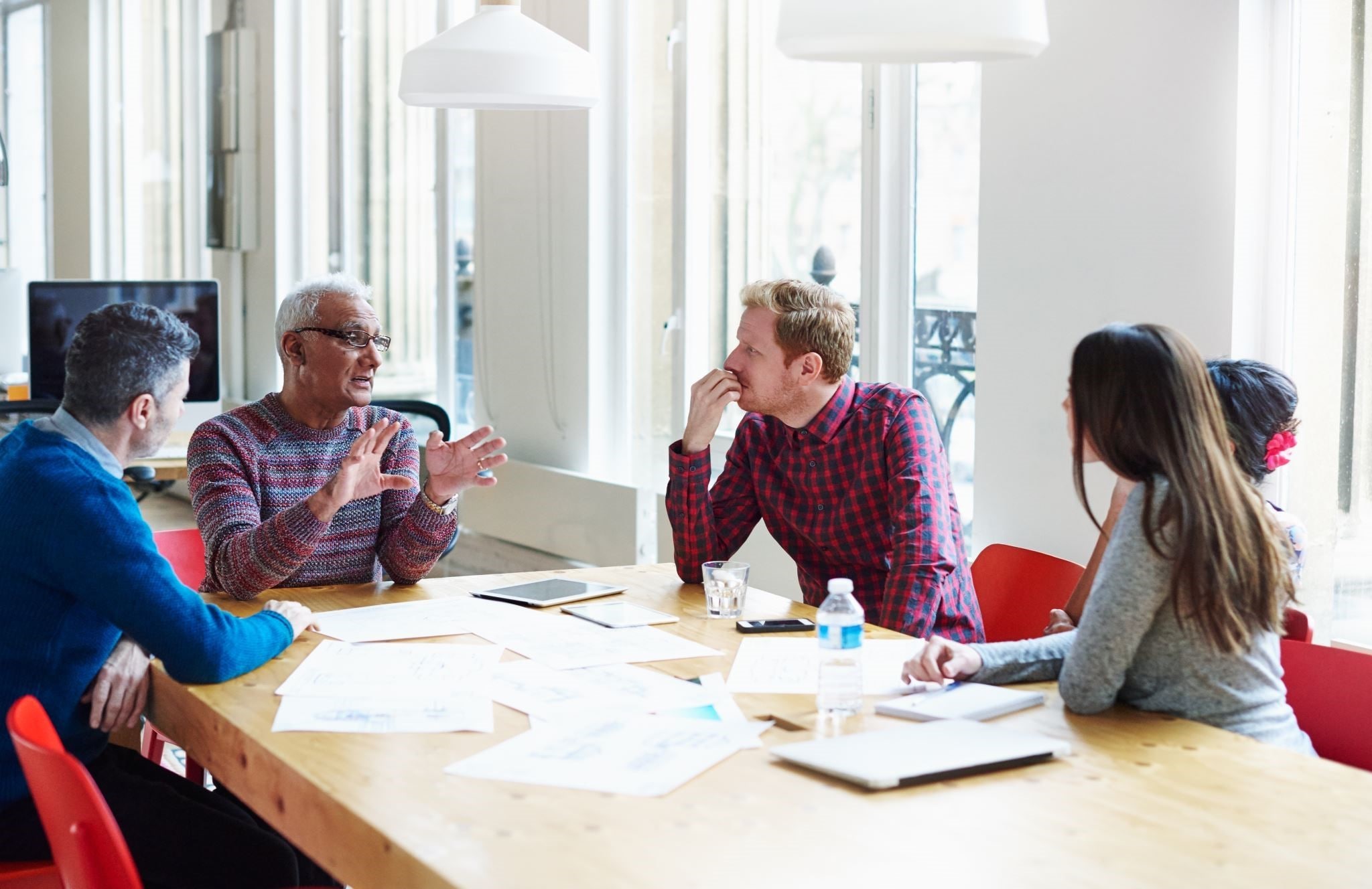 Image illustrating a leadership team engaged in a coaching discussion, highlighting their commitment to collective growth and shared leadership strategies